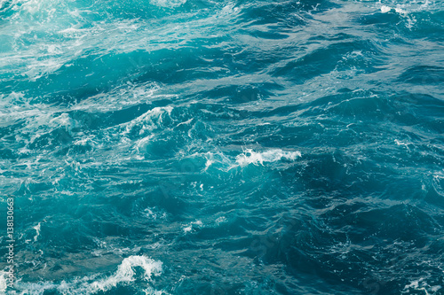 Blue sea water surface in motion with foam