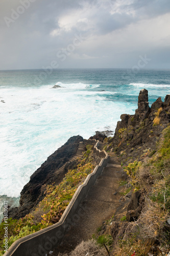 stairs on empty rocks near the town of garachico with view over atlantic ocean and blue sky