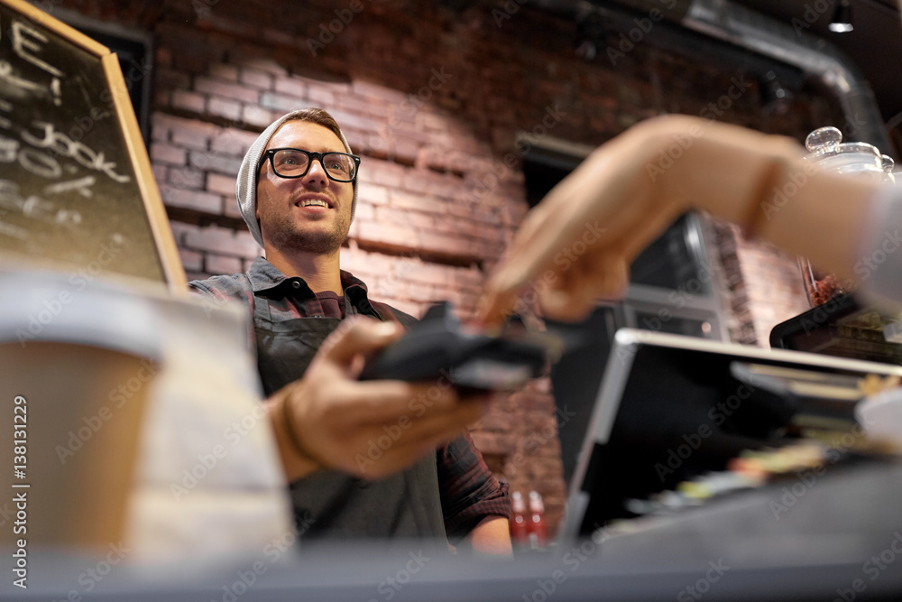 happy man with card-reader at bar or cafe happy man with card-reader at bar or cafe