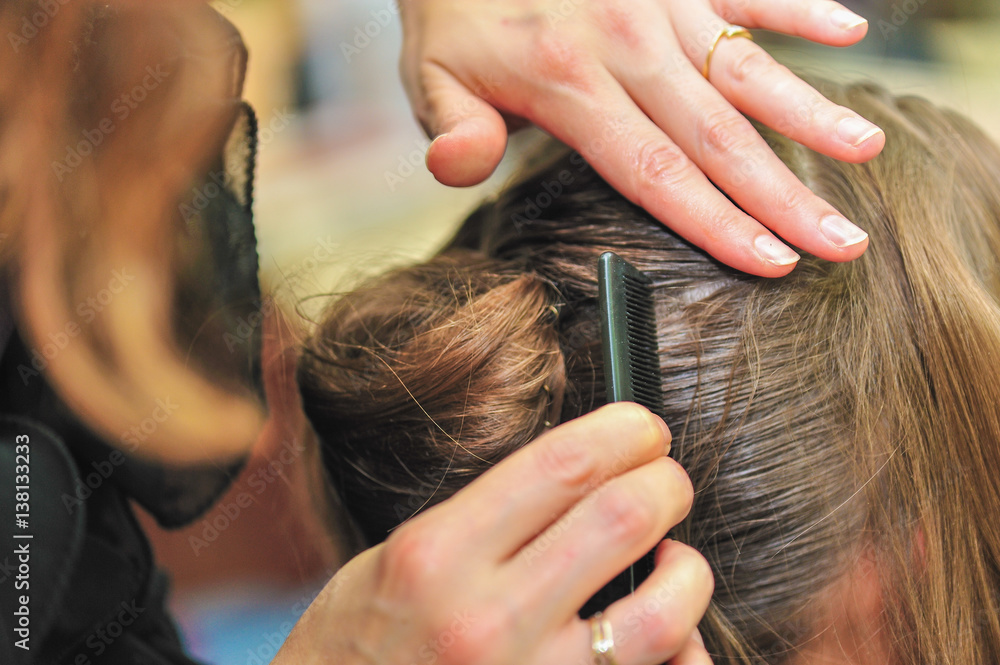 Fototapeta premium Hairdresser styling hair at the salon
