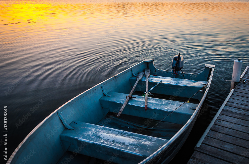 Fishing boat on tranquil lake at sunset in Minnesota Fishing boat on tranquil lake at sunset in Minnesota