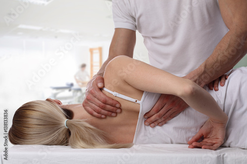 Woman having chiropractic back adjustment. Osteopathy, Alternative medicine, pain relief concept. Physiotherapy, sport injury rehabilitation photo