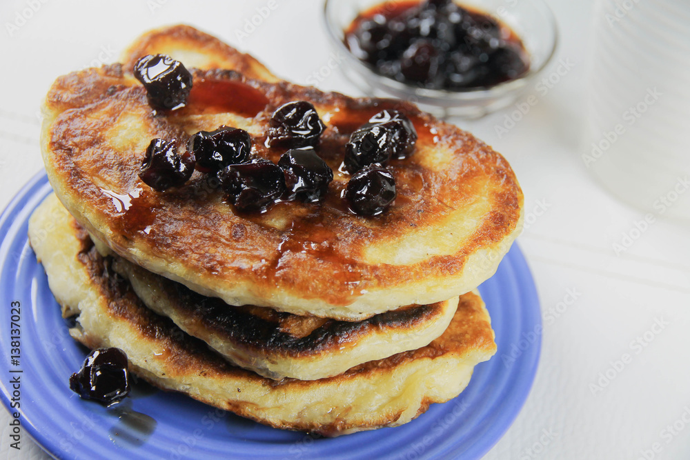 delicious pancakes with cherry jam on a blue plate delicious pancakes with cherry jam on a blue plate