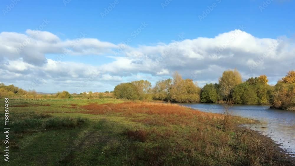 Green Grassy Fields rolls down to a rippling flowing river in the sunshine Green Grassy Fields rolls down to a rippling flowing river in the sunshine