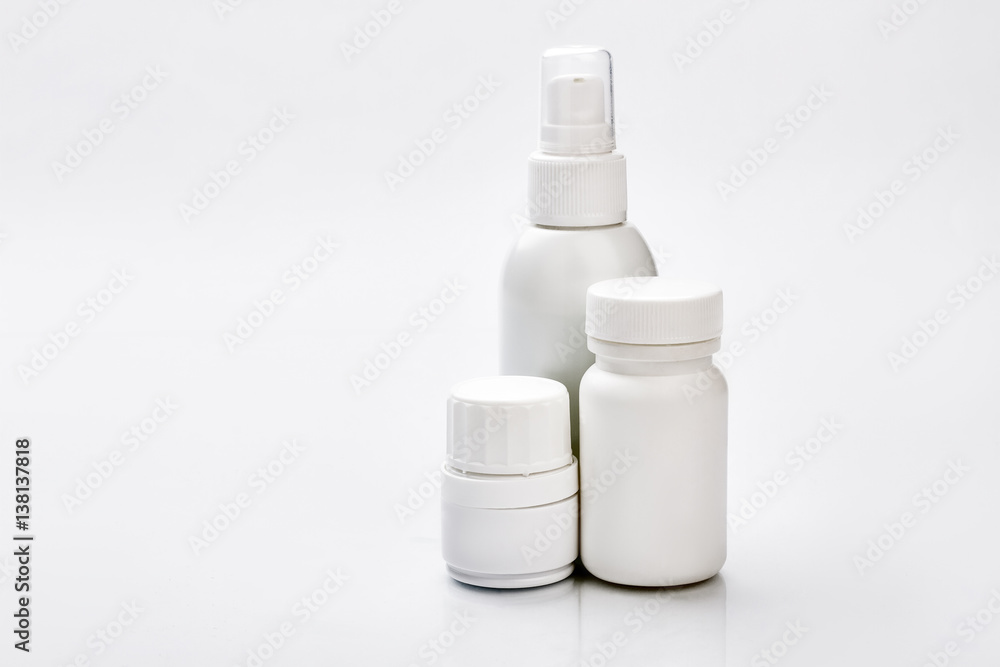 White plastic containers for pills. Little spray bottle. Dose of vitamins for month. White plastic containers for pills. Little spray bottle. Dose of vitamins for month.