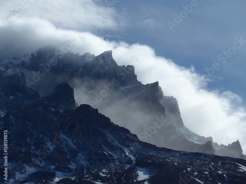 Clouds swirling around the peaks of large towers in the strong Patagonia winds in Torres del Paine National Park.  © mat_millard