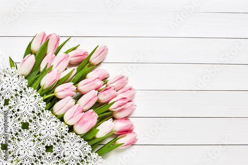 Bouquet of pink tulips, white tablecloth. Top view, copy space