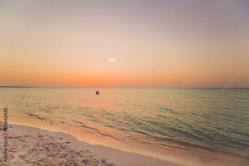 amazing stunning, gorgeous sunset time at Cuban Cayo Coco island with people relaxing in the ocean