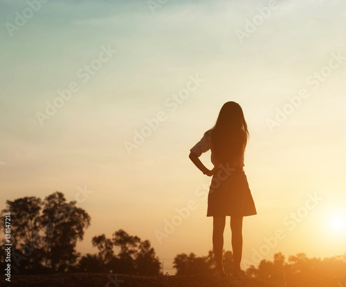 Silhouette of woman praying over beautiful sky sunset background