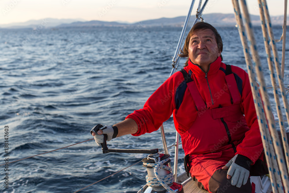 Man on his sailing yacht. StockFoto Adobe Stock