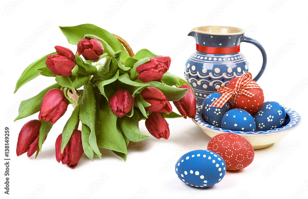 Blue ceramics with Easter eggs and red tulips on white