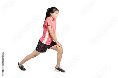 Portrait of a beautiful asian woman warming up for running. Isolated full length on white background with copy space