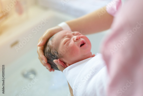 asian newborn bathing by his mother, baby boy