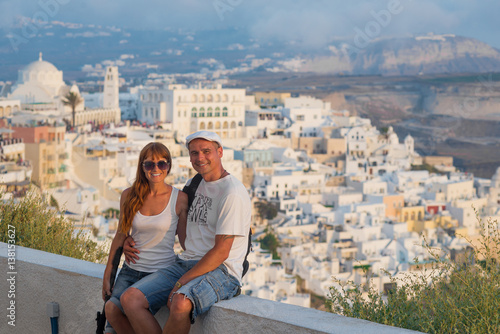 Couple on island of Santorini. Cheerful couple travels to islands of Greece, the most romantic island -Santorini. concept of family tourism and travel, Man and woman on the background of sunset city 