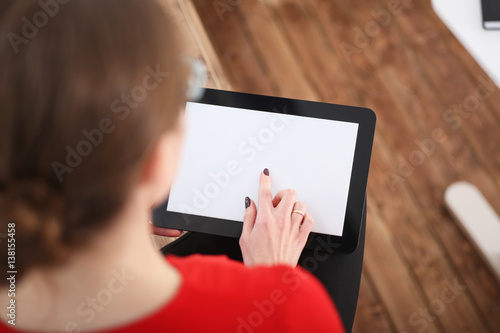 Woman holding tablet in hands. He presses his finger on the display