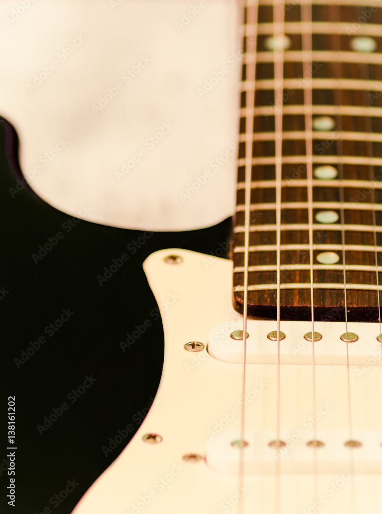 Black and white electric guitar on white background, close up, selective focus Black and white electric guitar on white background, close up, selective focus