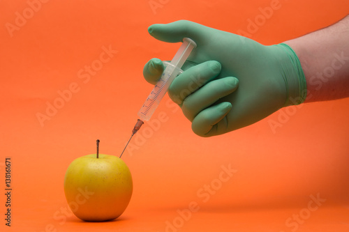 GMO apple with syringe on the white