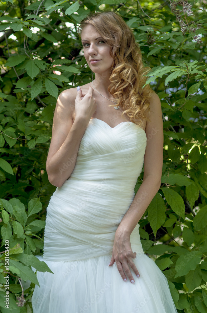 Young girl with red hair beautiful hair and makeup in a white dress of the bride in the park
Young girl with red hair beautiful hair and makeup in a white dress of the bride in the park