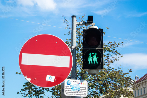 VIENNA, AUSTRIA - JULY 29, 2016: A close-up view of a green traffic light with an image of two walking lesbian girls at the center of Vienna, Austria.