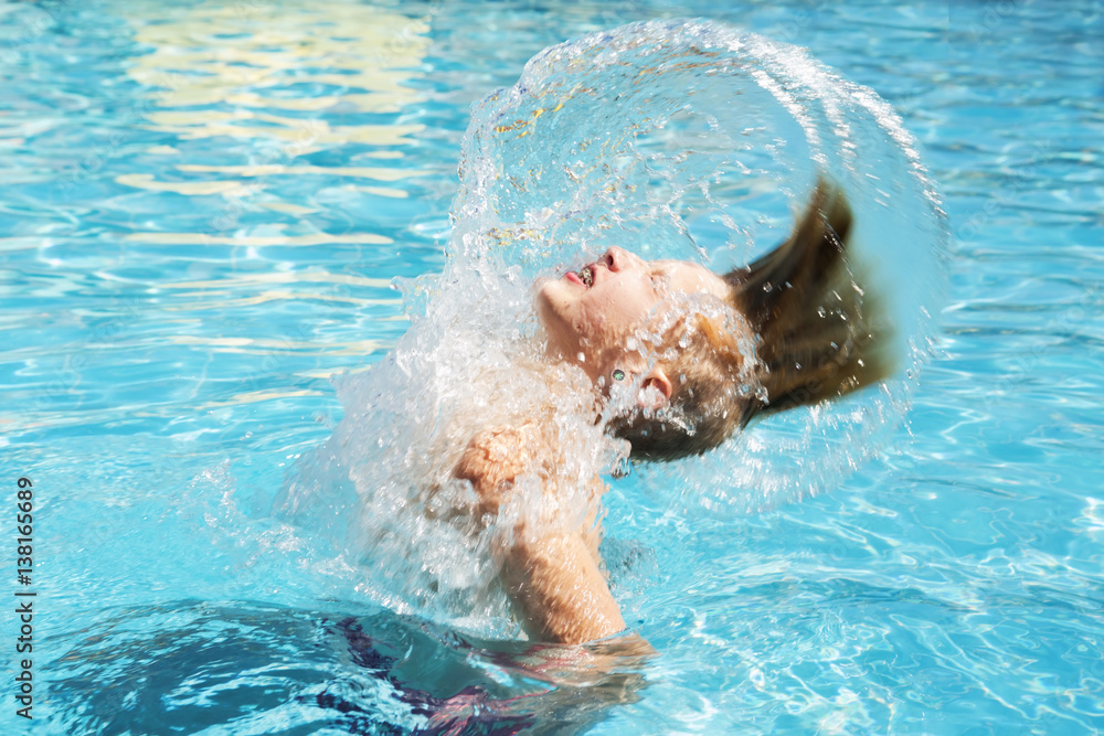 Teenager dives and has fun in aquapark. Splash in water.