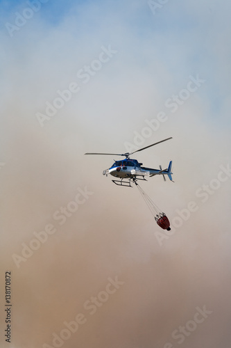 hélicoptère au dessus d'un feu avec un sac d'eau