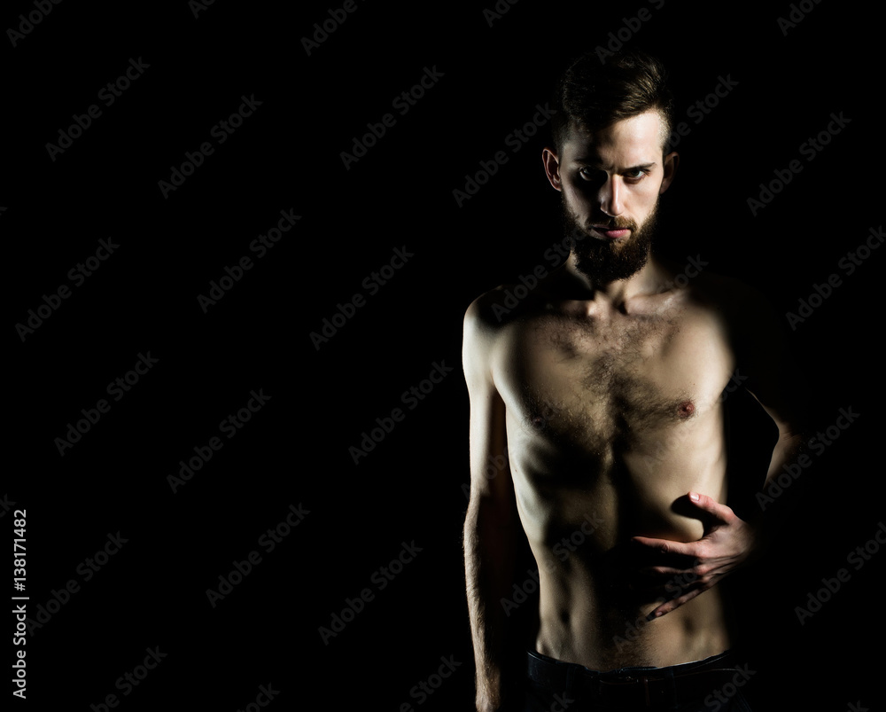 slim bearded man with thin bare torso isolated on black
