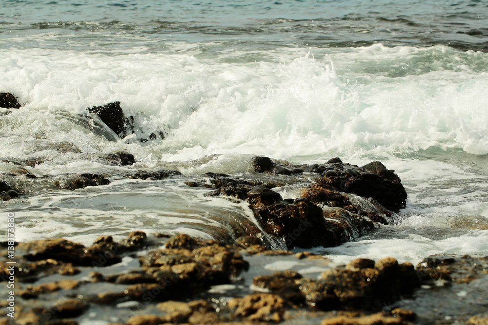 Beautiful grey sea stormy waves splash against black stony shore Beautiful grey sea stormy waves splash against black stony shore