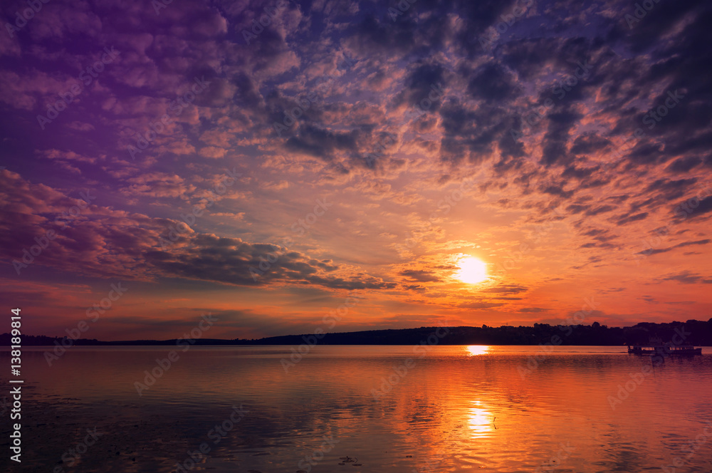 majestic sunset at the lake. colorful clouds in the sky gloving in sunlight.