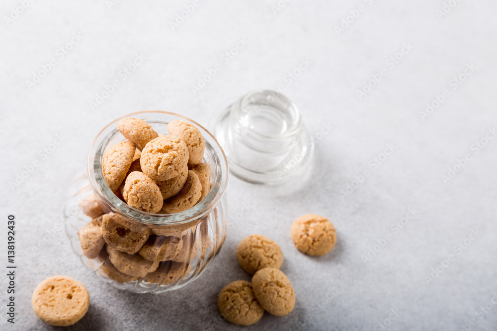 Amaretti cookies in glass pot on light gray background with copy space. High angle view Amaretti cookies in glass pot on light gray background with copy space. High angle view