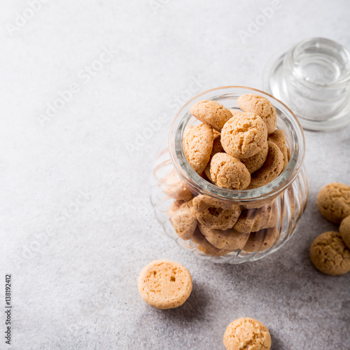 Amaretti cookies in glass pot on light gray background with copy space. High angle view