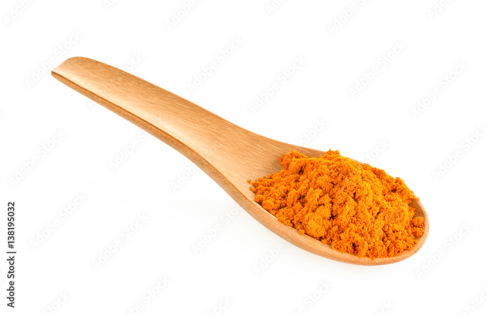 Turmeric powder in a wooden spoon on a white background Turmeric powder in a wooden spoon on a white background