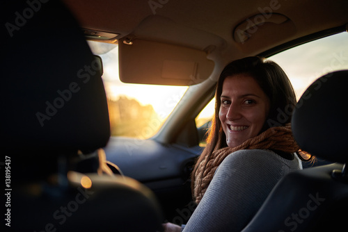 Mujer joven en el asiento delantero de un coche