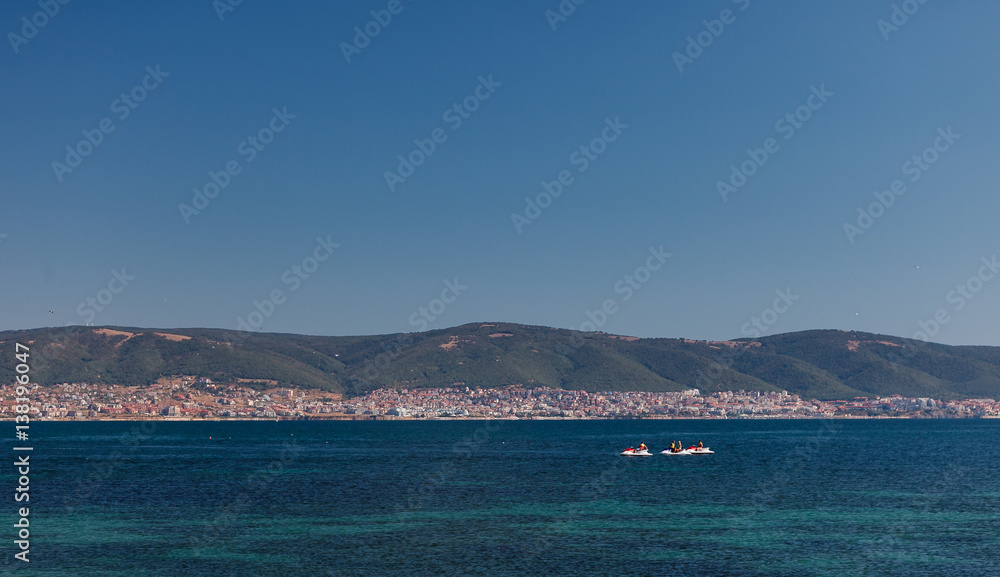 People on the watercraft at sea on the background of the Sunny Beach resort in Bulgaria.