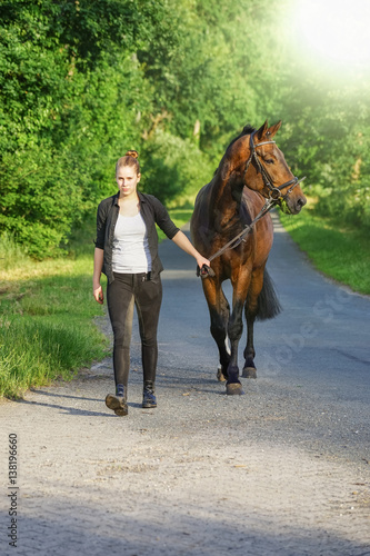 Leidenschaft für Pferde - Mädchen mit Pferd auf einem Waldweg