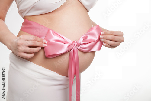 Wallpaper Mural belly of a pregnant woman in white with a pink bow, newborn girl Torontodigital.ca