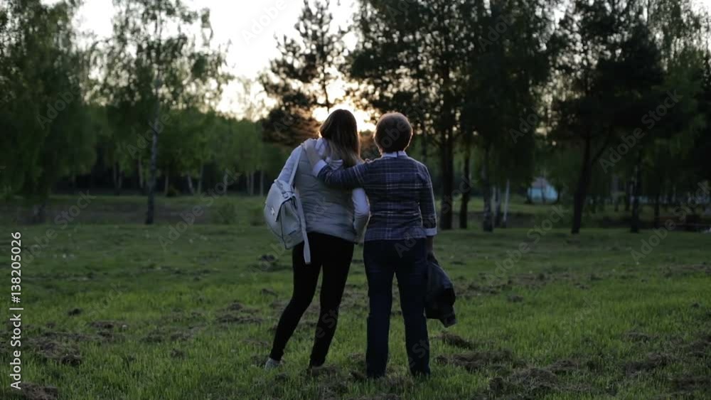 Mother and daughter looking at a beautiful sunset in the park. Mother and daughter looking at a beautiful sunset in the park.