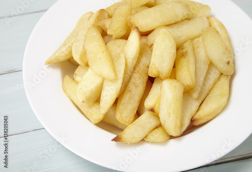 A bowl of French fries on a blue wooden dining table background