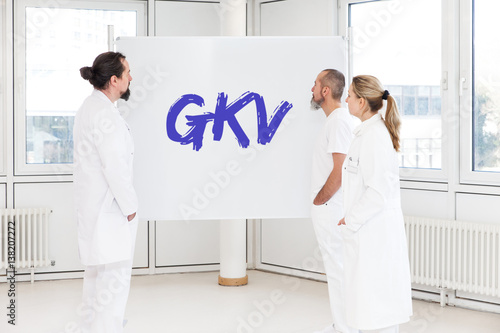 Mediziner stehen vor weißer Tafel, GKV oder gesetzlicher Krankenversicherung photo