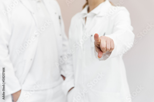 Zwei Ärzte im Hintergrund, Finger zeigt auf Textfreiraum