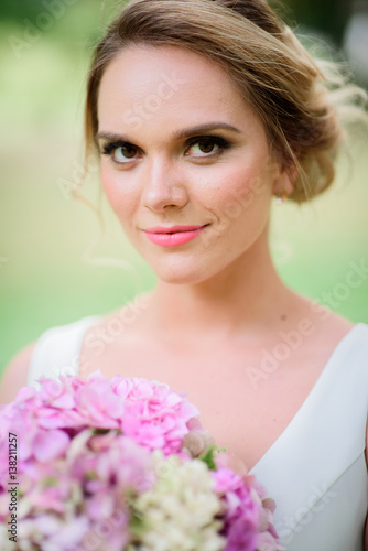 Awesome blonde bride looks charming with her pink bouquet of hydrangeas