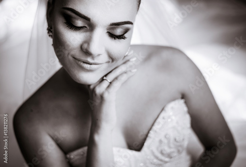 Black and white picture of gorgeous bride touching her face tender