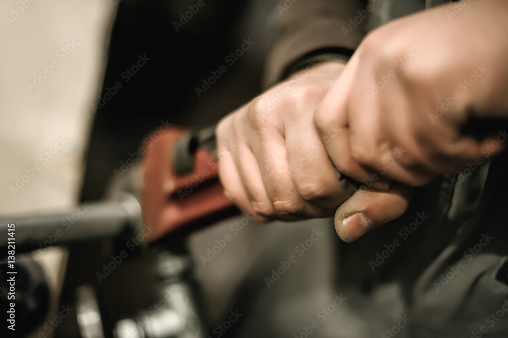 Carpenter using plier for his job in carpentry workshop