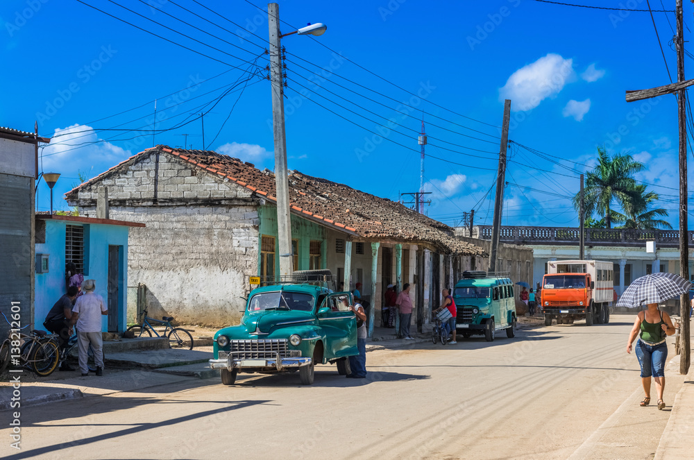 Straßenszene in Santa Clara Kuba mit einem parkendem blauen Oldtimer - Serie Kuba Reportage