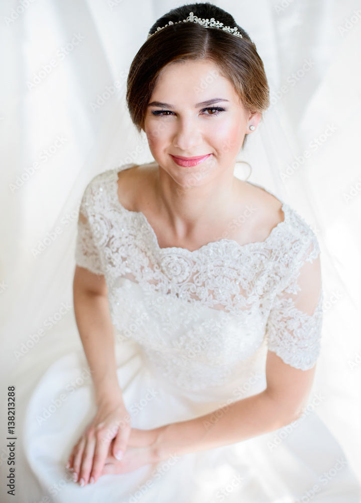 Charming bride holds her hands on knees while she sits Charming bride holds her hands on knees while she sits