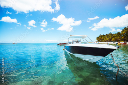 Shot of yacht on crystal water. Tropical island. Voyage concept. Tropical scene. Long palm trees.
