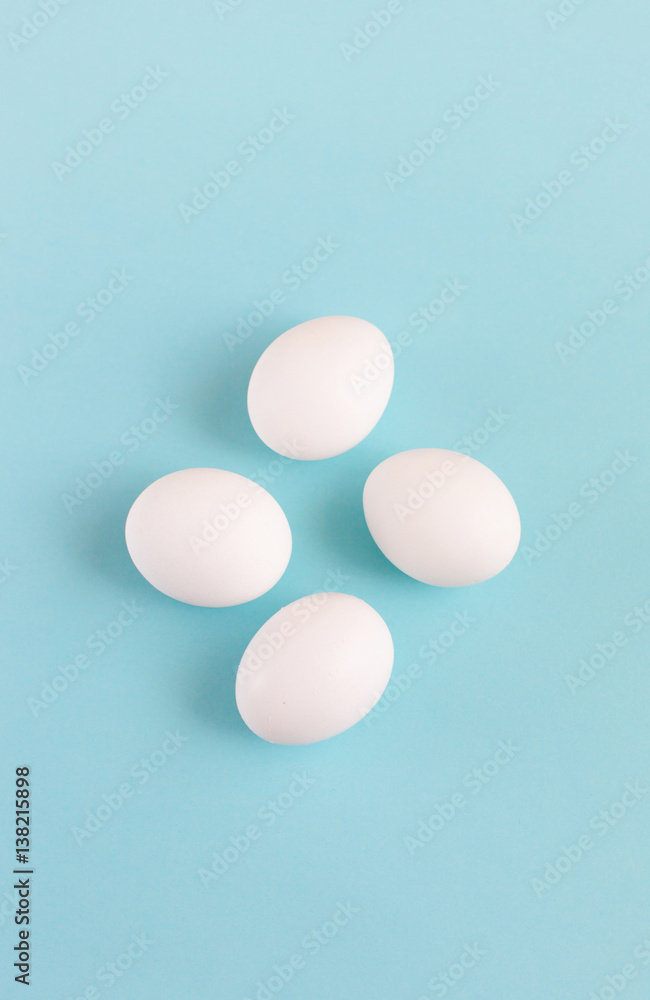 Easter decoration white eggs on a light blue background, minimal design with space for text, vertical image Easter decoration white eggs on a light blue background, minimal design with space for text, vertical image