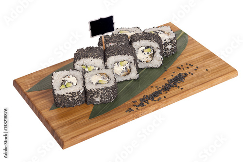 Φωτογραφία Sushi rolls on wooden Board with leaves of leeks and black sign for logo and nam