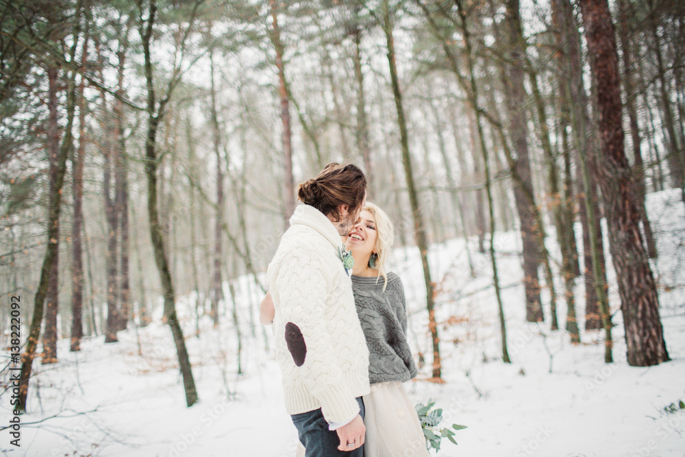 Beautiful smiling romantic couple in the winter forest outside Beautiful smiling romantic couple in the winter forest outside