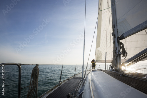 Man Standing On Front Of Yacht Deck In Sea Against Sky © Tyler Olson