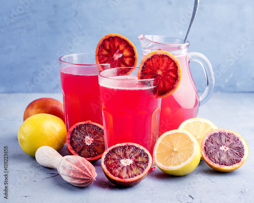 Glasses with blood orange and lemon lemonade Place for text Blue background
